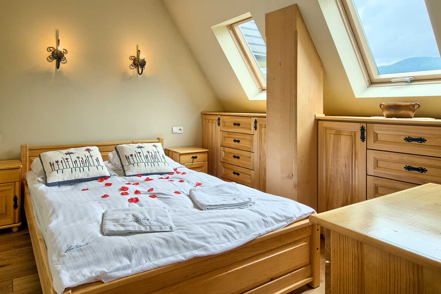 Sypialnia w apartamencie w góralskim stylu z łóżkiem małżeńskim i drewnianymi meblami